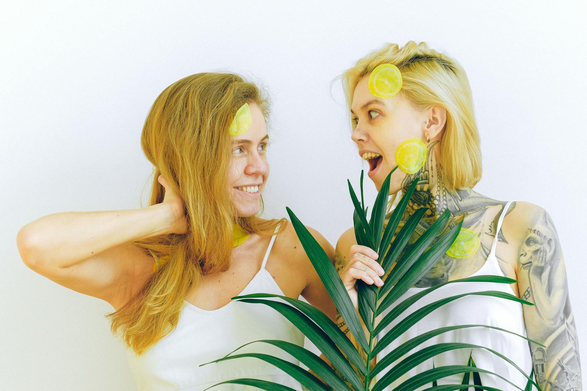 Two women smiling with lemon slices, expressing joy and openness during intimate conversation