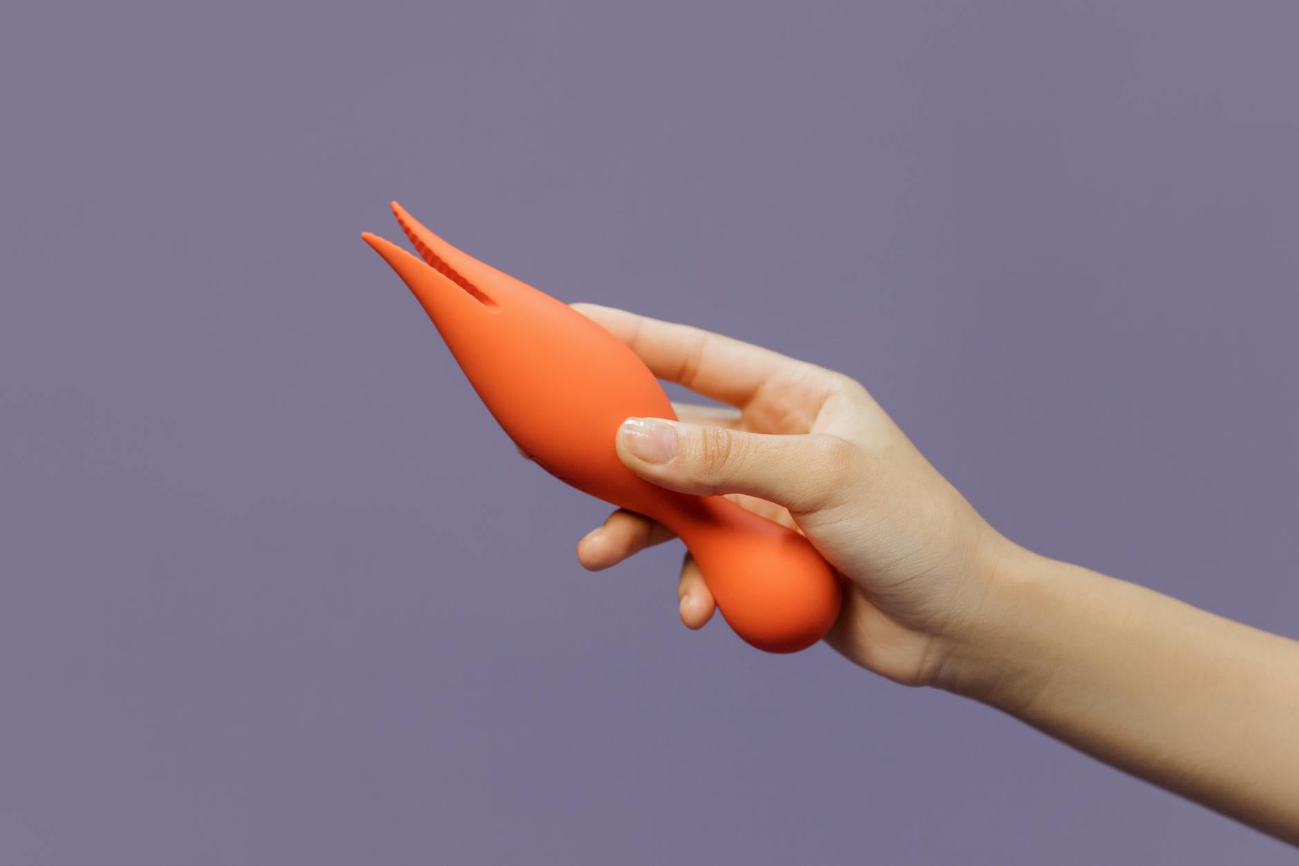 Hand holding a lemon vibrator against a minimalist purple backdrop, symbolizing gentle self-care and sensual healing