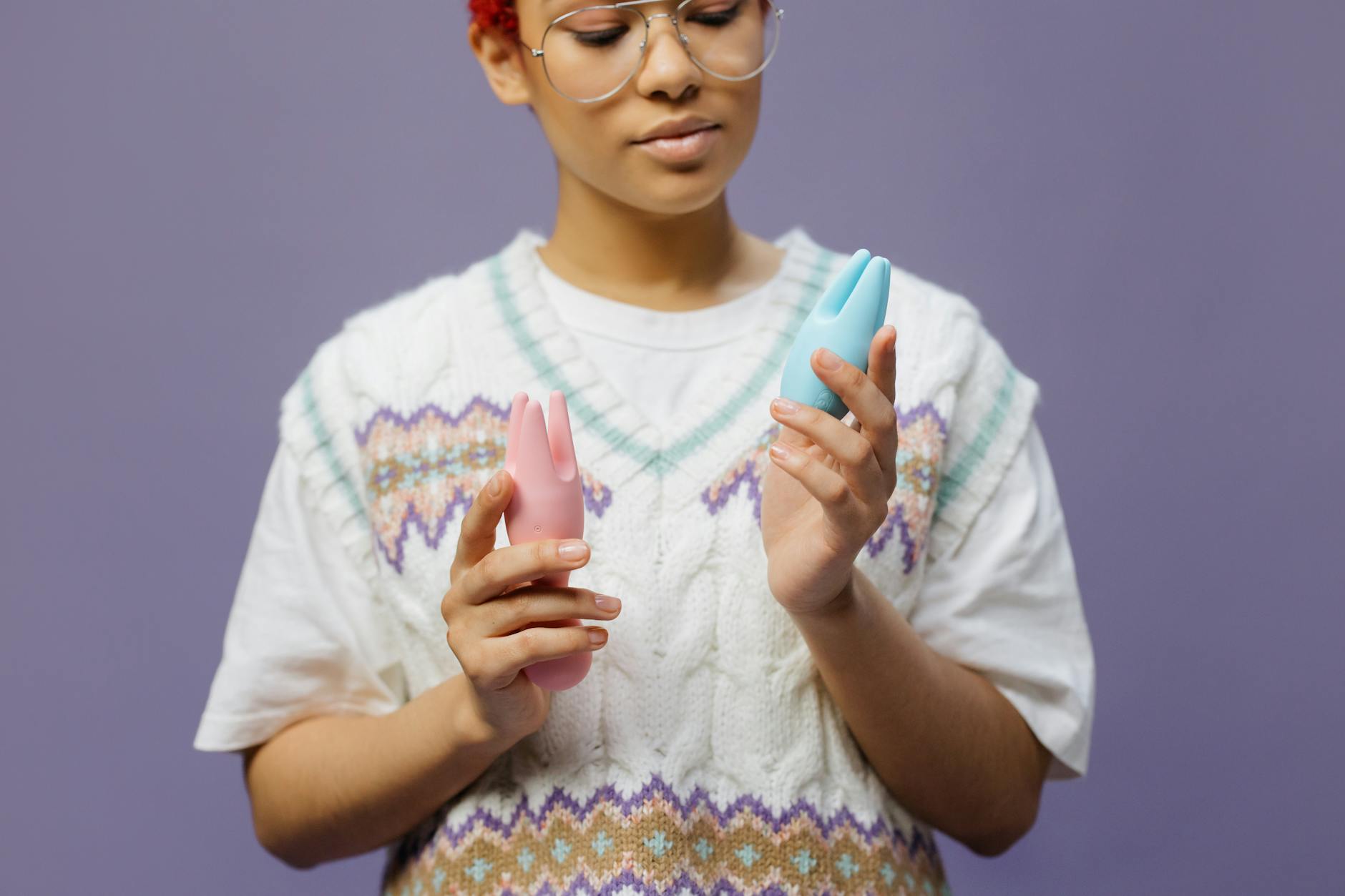 Woman thoughtfully holding lemon vibrators, considering restarting sexual activity