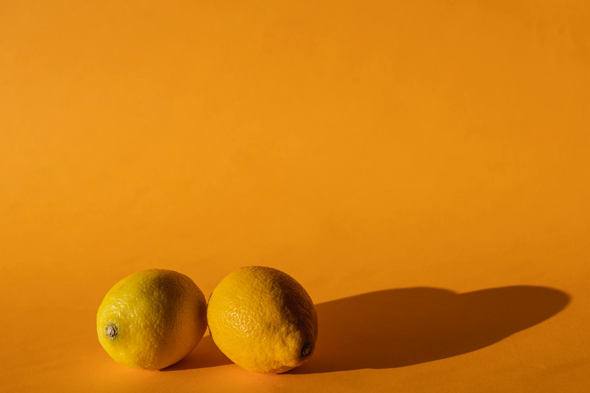 Fresh lemons on a bright yellow background symbolizing natural pleasure and vitality
